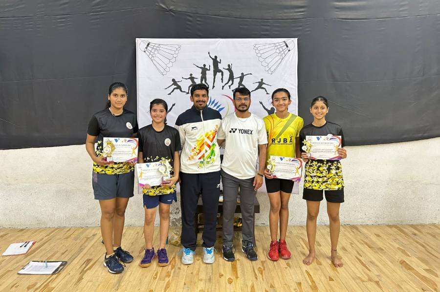 Coaches and students posing with trophies and certificates