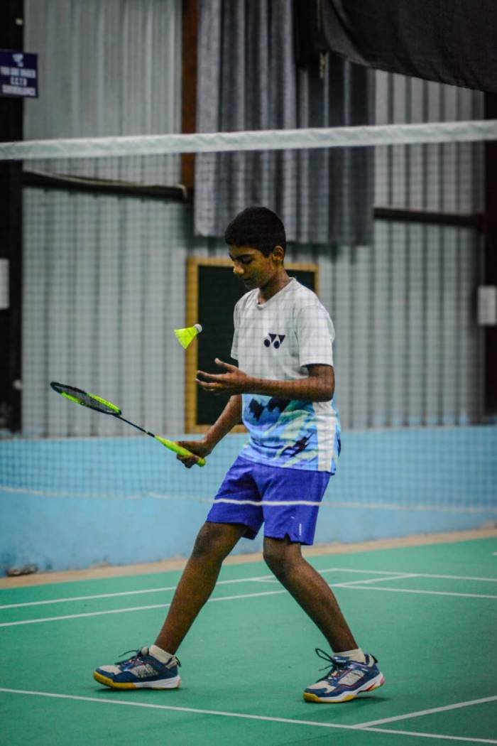 Student about to serve a shuttlecock at the net