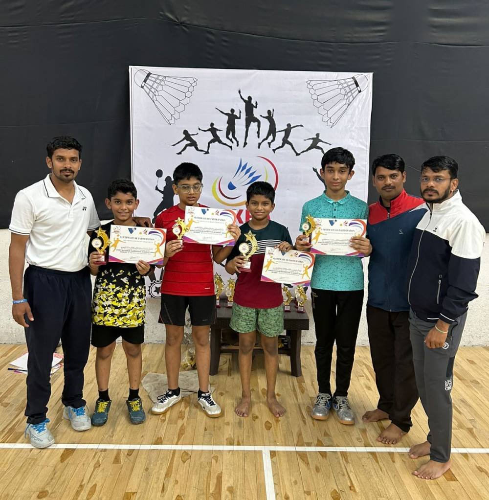 Coaches with young players holding certificates and trophies