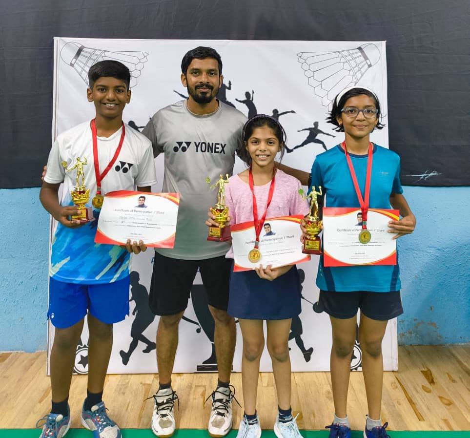 Coach with three students holding trophies and certificates